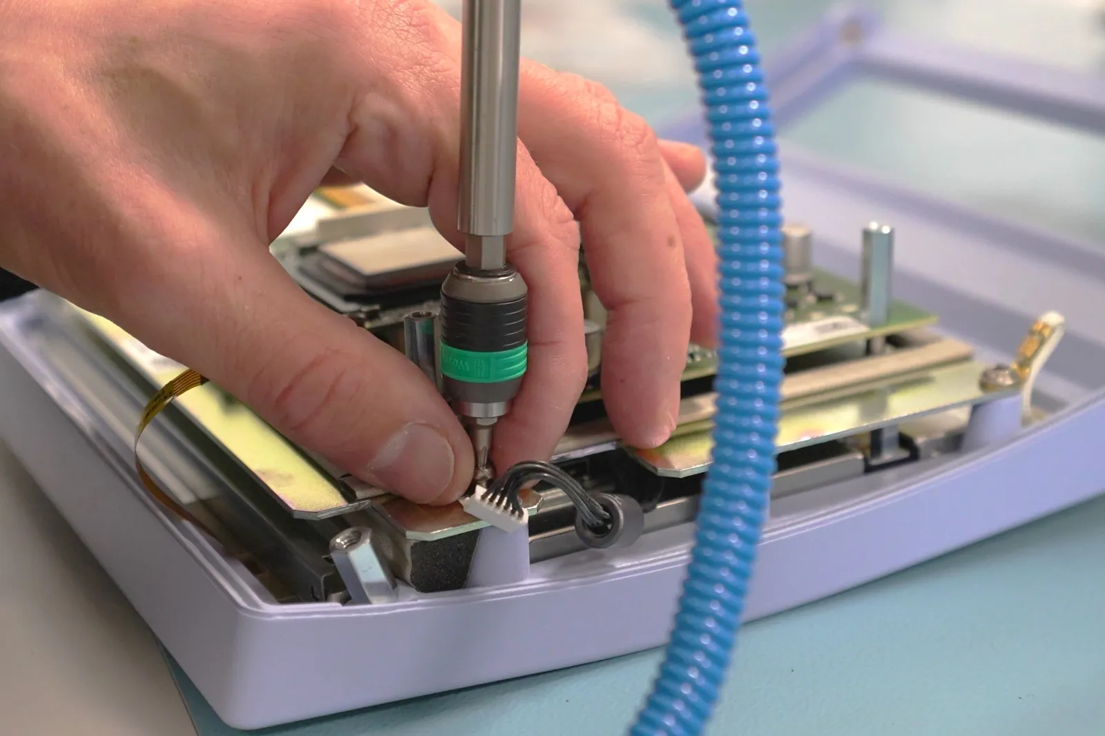Close-up of a 360 Biomed engineer carrying out precision repair work on a medical device circuit board
